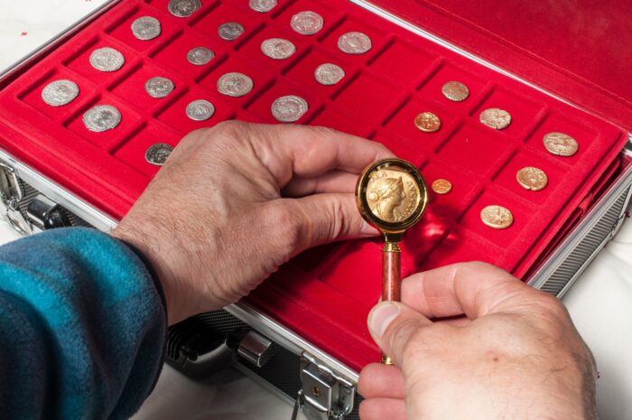 Kolekcjoner monet sprawdzający jak wygląda znak mennicy podczas wyceny monety i weryfikacji jej autentyczności.