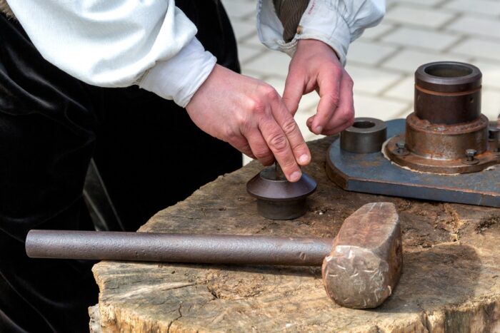 Mincerz pracujący w mennicy - osoba zajmująca się biciem monet.